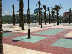 Palm trees line a paved plaza