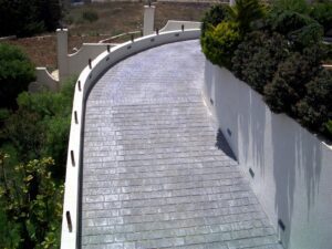 Curved stone driveway with white walls