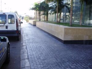 Urban sidewalk with palm trees and vehicles