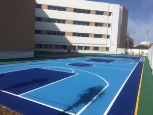 Outdoor blue basketball court near building