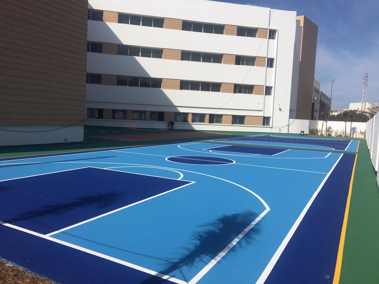 Outdoor blue basketball court near building
