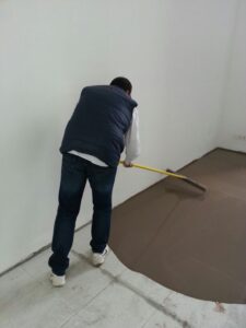 Worker smoothing concrete surface