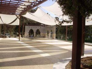 Covered outdoor area with arches and trees