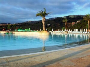 Poolside with palm trees and hills