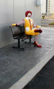 Colourful clown figure on outdoor bench