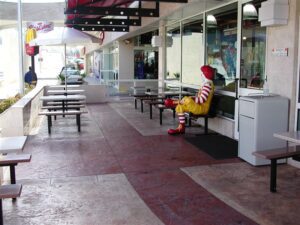 Empty outdoor dining space with clown statue