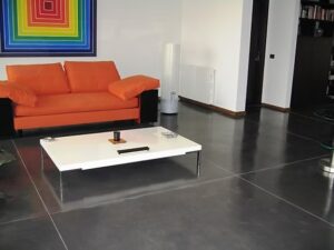 Orange sofa and colourful artwork in living room.