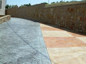 Patterned concrete driveway with stone wall