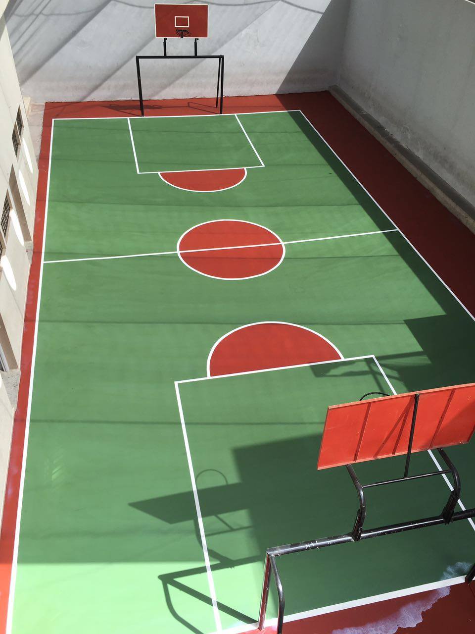 Rooftop basketball court with two hoops.