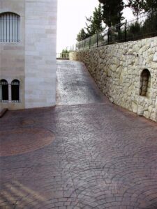 Cobblestone path leading uphill near stone fence