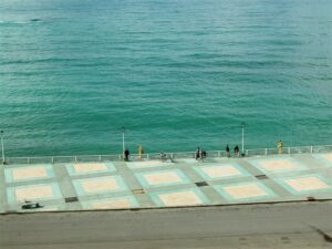 People enjoying coastal boardwalk scenery