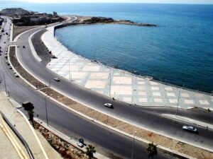 Curved road beside a calm blue sea