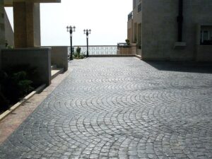 Sunlit cobblestone path between buildings