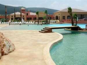 Resort pool area with loungers and trees