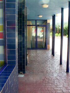 Blue-tiled hallway with glass door entrance