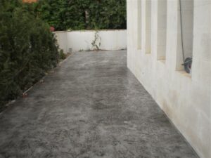Outdoor walkway next to white wall