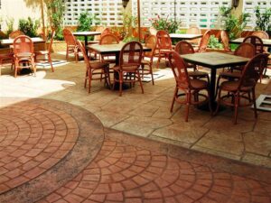 Sunlit cafe patio with wicker furniture.