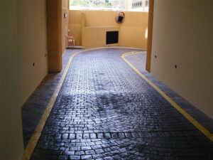 Curved cobblestone driveway with yellow lines.