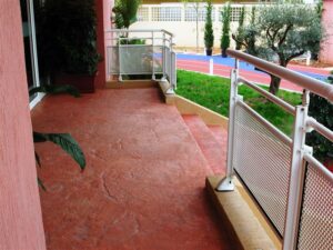 Balcony with red flooring and plants