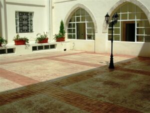 Empty courtyard featuring potted plants and windows