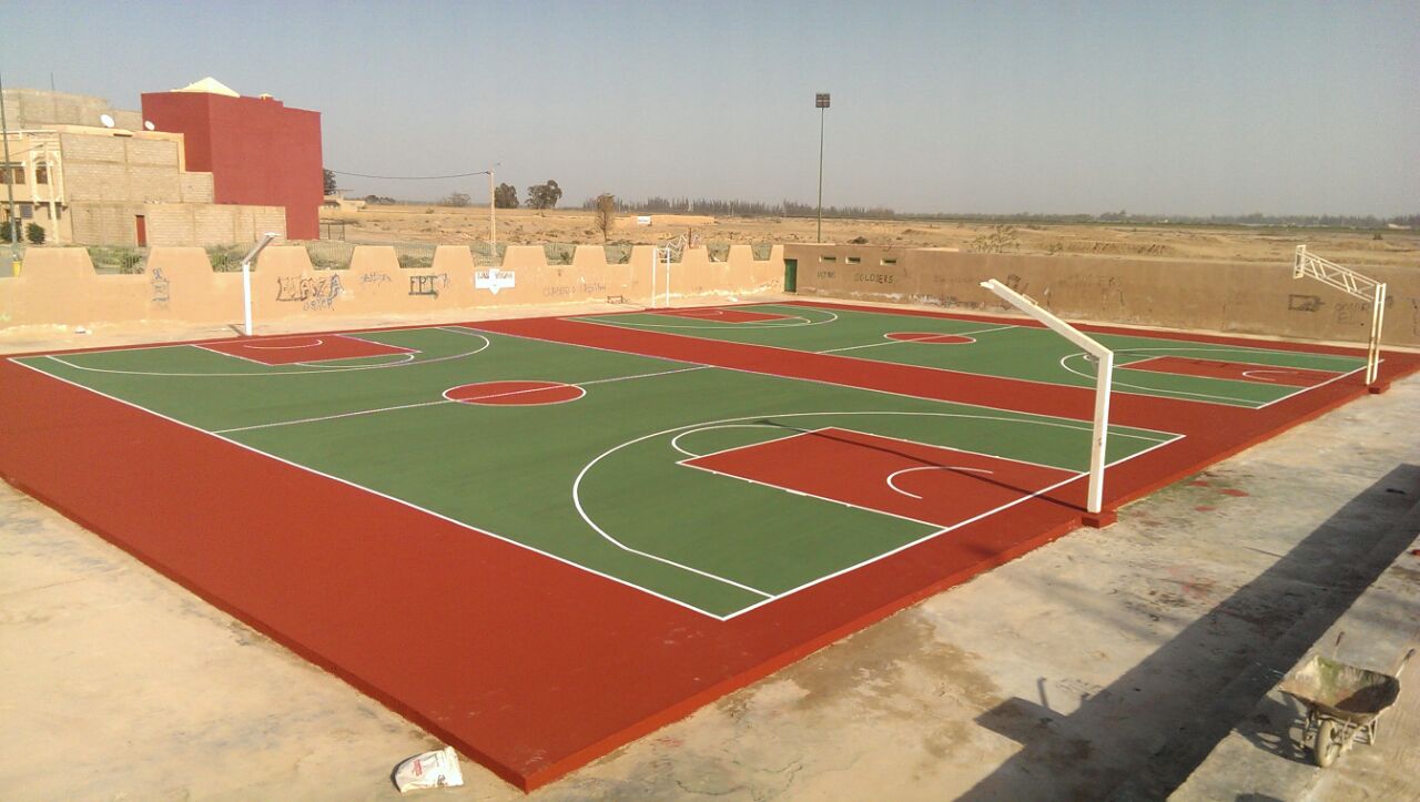 Empty basketball court under clear sky.