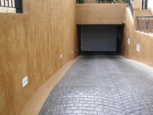 Sloped driveway leading to a closed garage