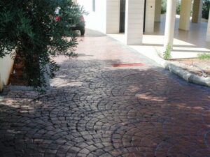Shaded driveway with red brick paving design.
