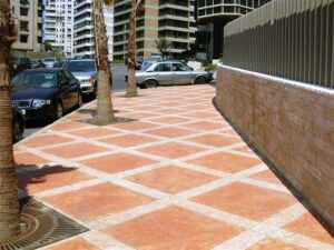 Tiled sidewalk with parked cars and trees