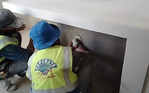 Two workers applying concrete finish