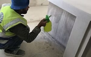 Worker spraying liquid on a wall