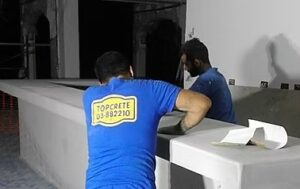 Two men working on concrete surface